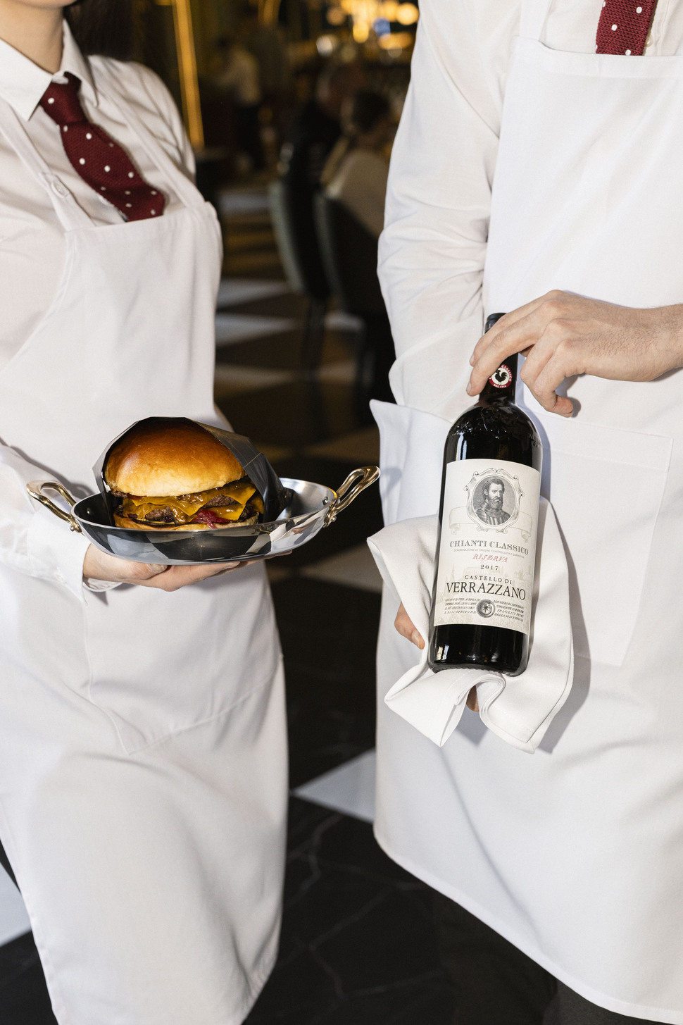 waiter with burger and bottle of wine